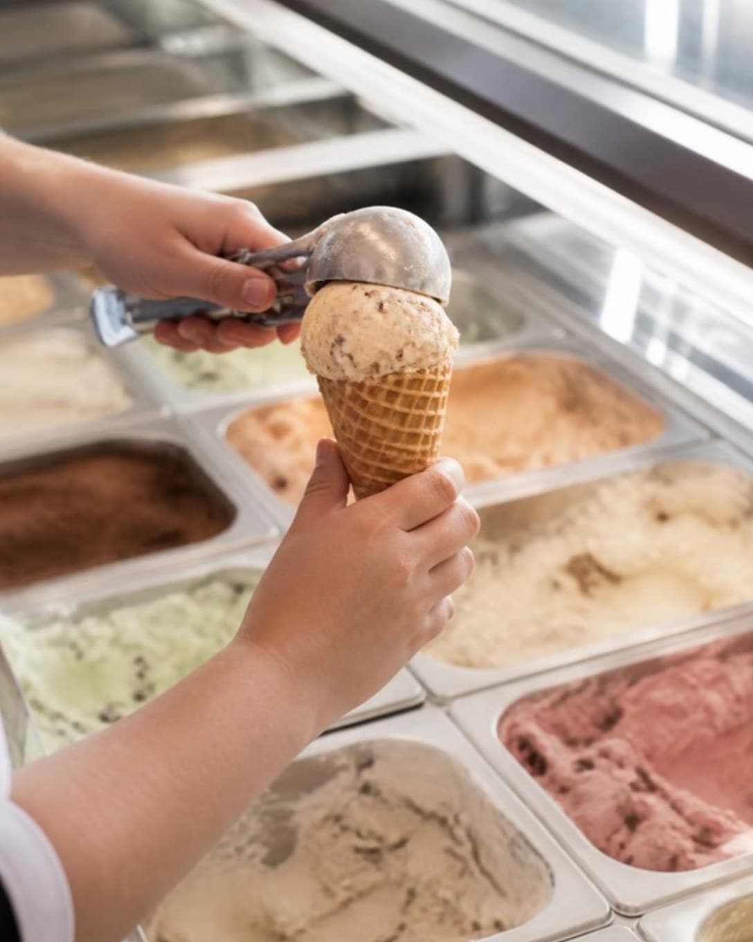 Server scooping ice cream into a cone